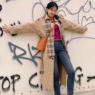kimehwa posing against a graffiti wall with checked scarf draping around her neck